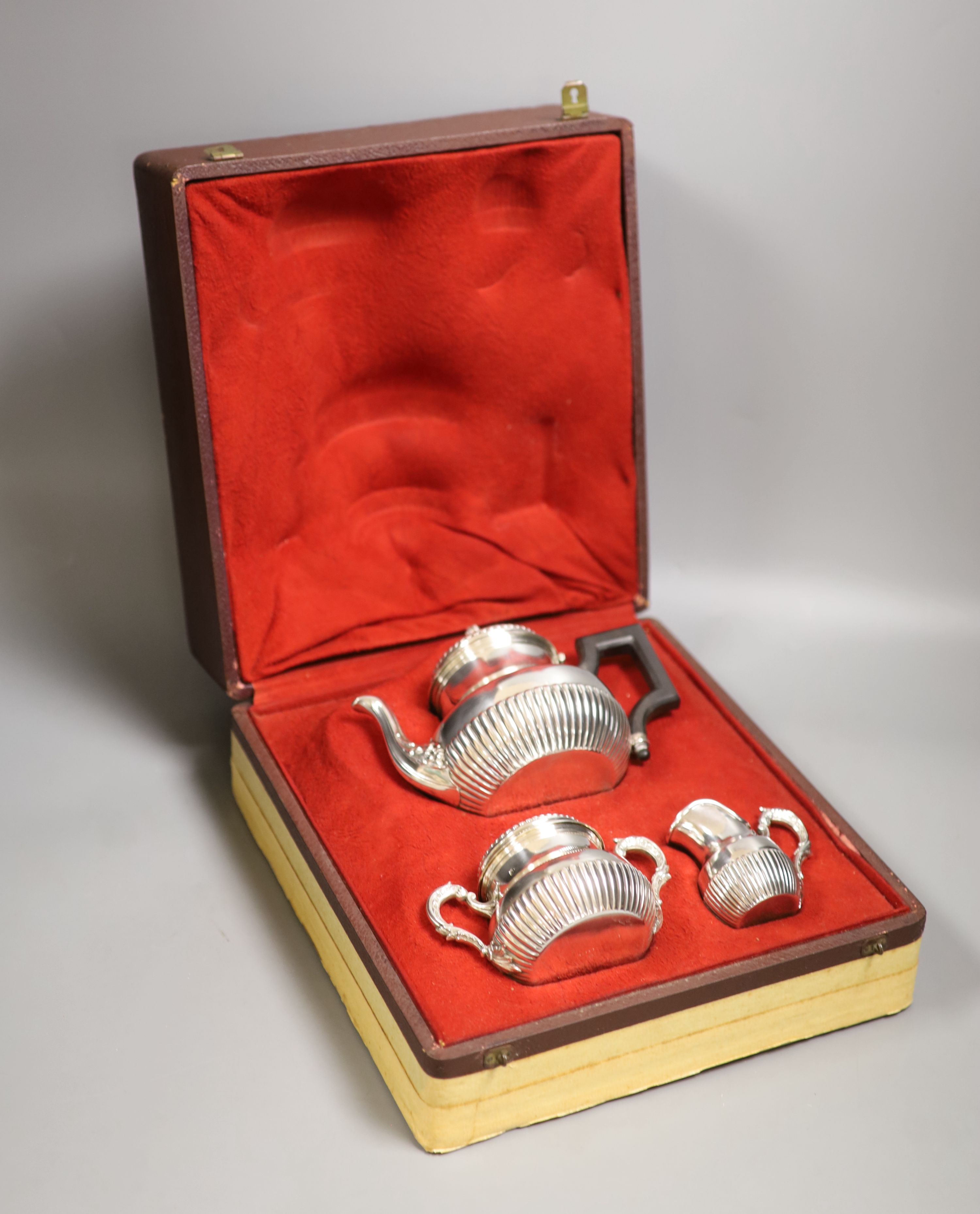 A cased late 19th/early 20th century French demi fluted white metal three piece tea set, by Edmond Tetard